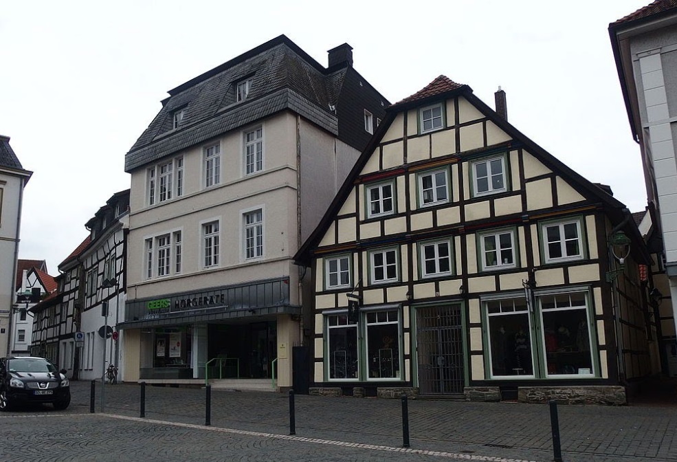 Ein Fachwerkhaus neben einem modernen Gebäude in der Stadt Soest, Deutschland.